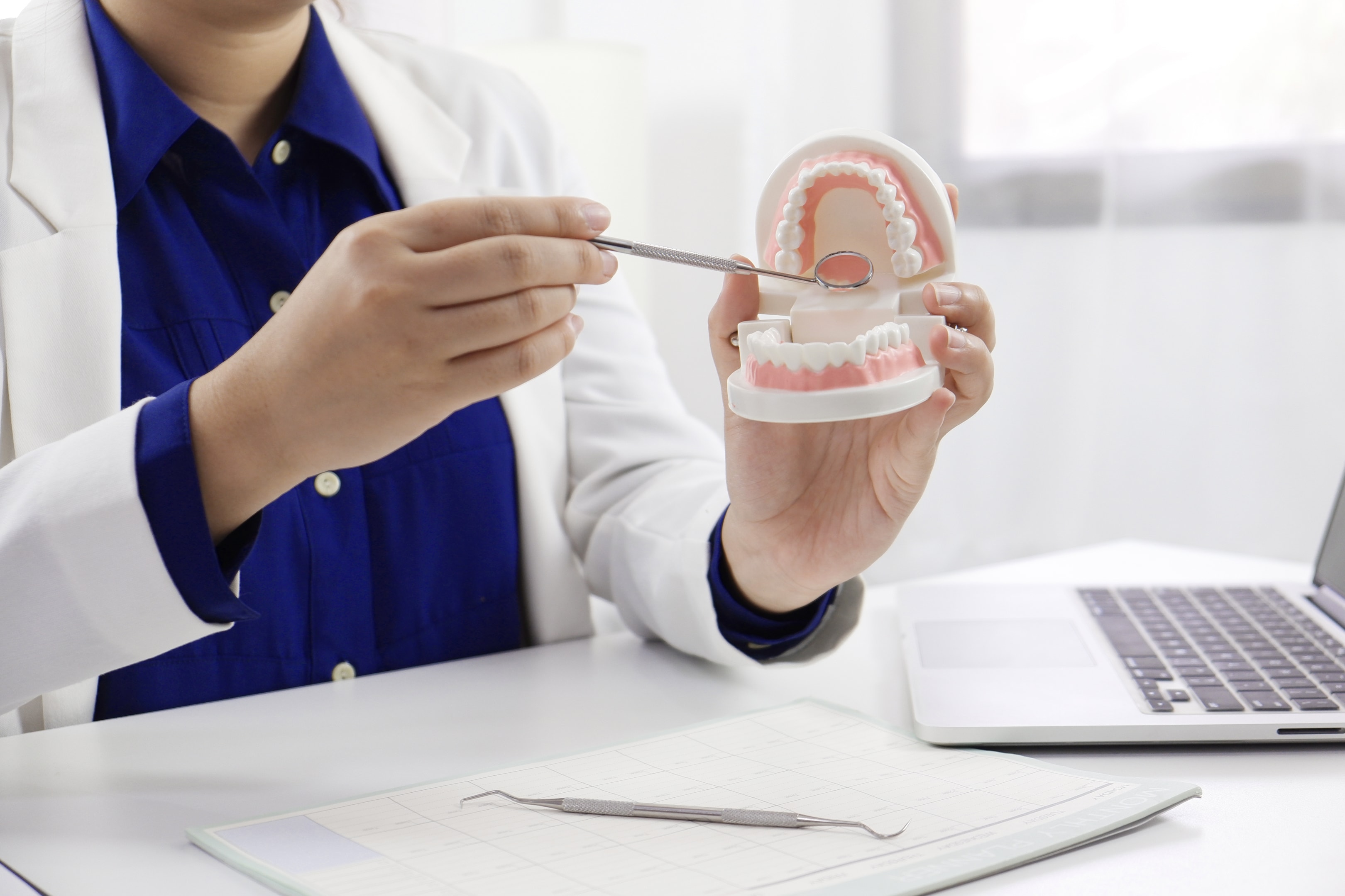 an oral surgeon explaining a simple tooth extraction to a patient as well as future tooth replacement options
