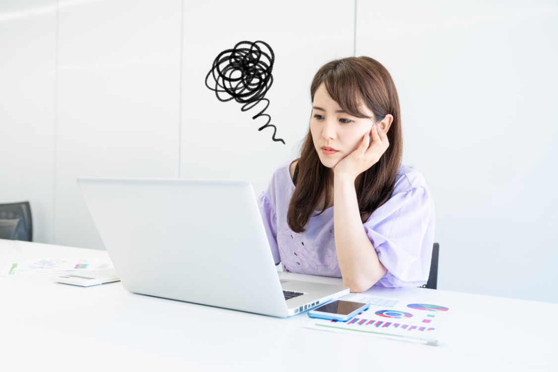 Confused Filipino employee staring at a laptop, unsure about unclear job instructions.