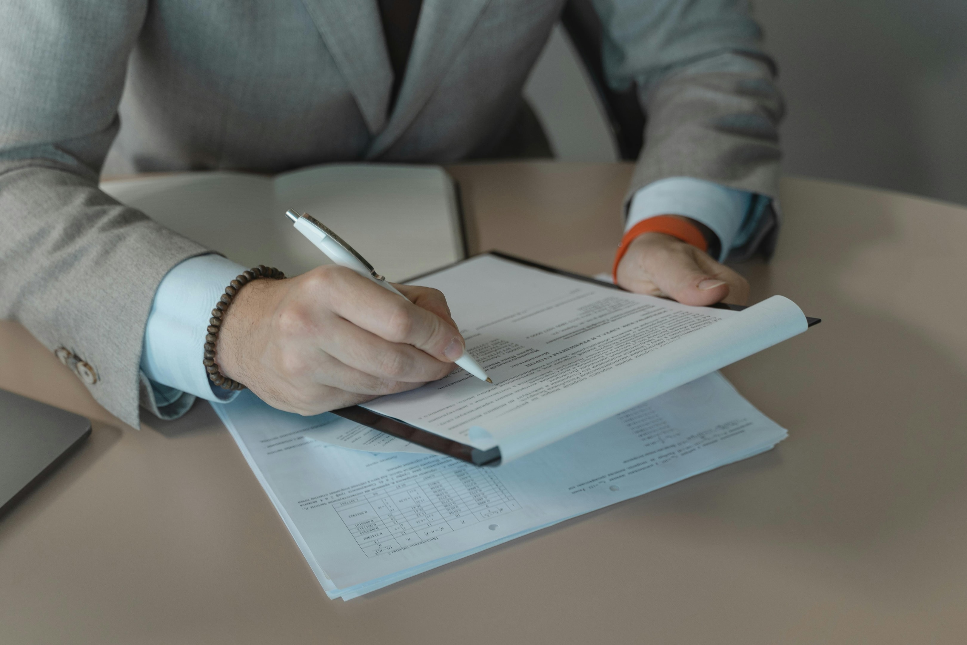 man signing document with pen