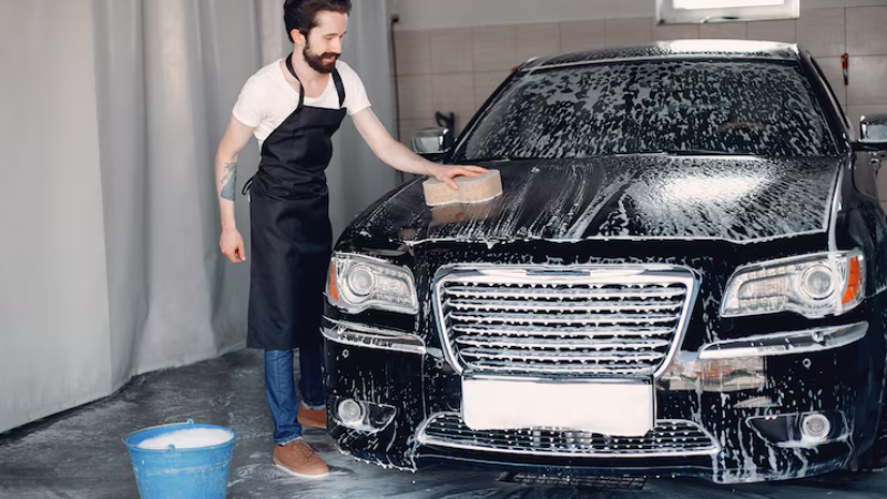 A professional is preparing car for PPF installation by washing it with Isopropyl alcohol solution