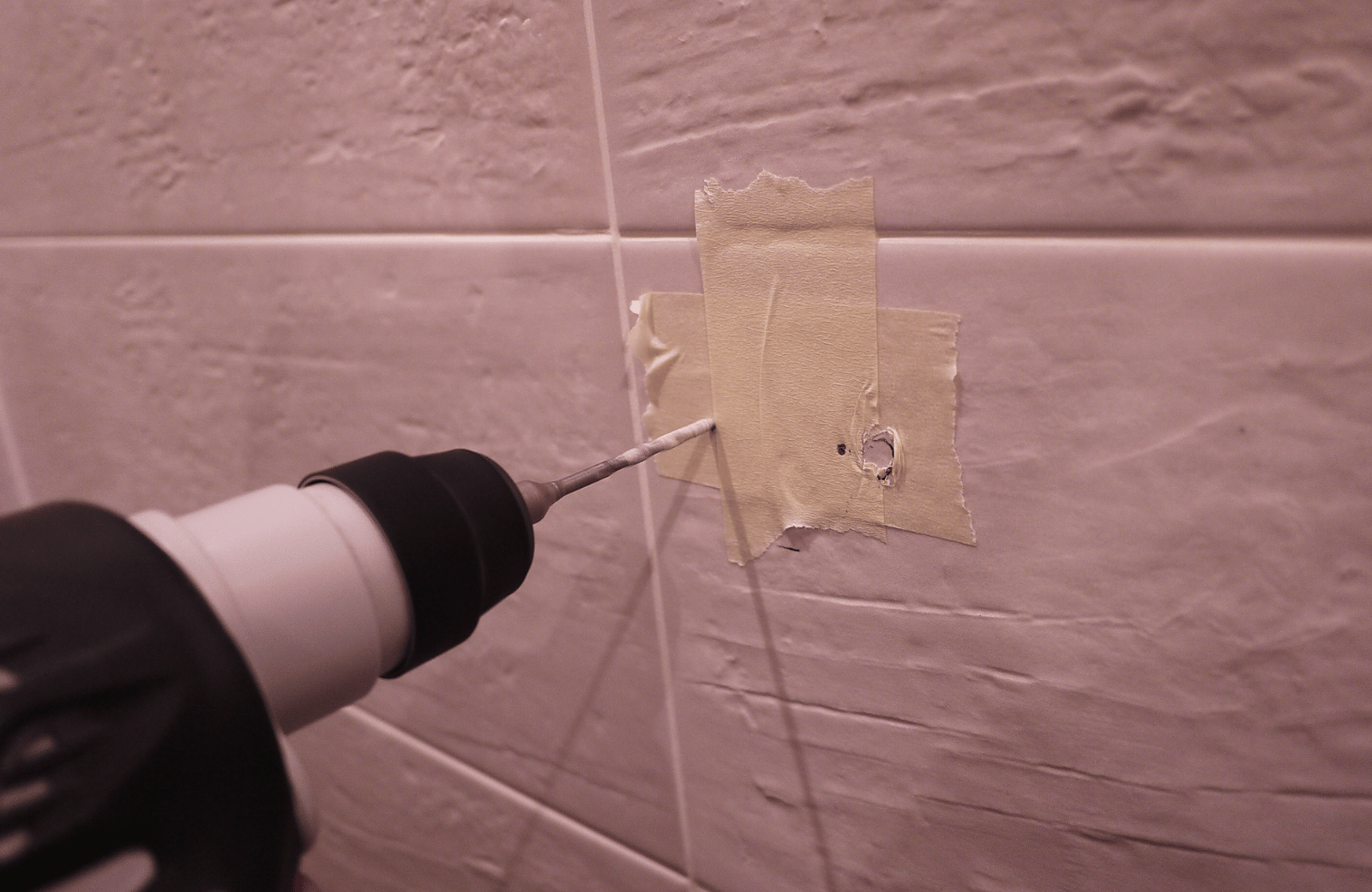 drilling through a marked spot on tile