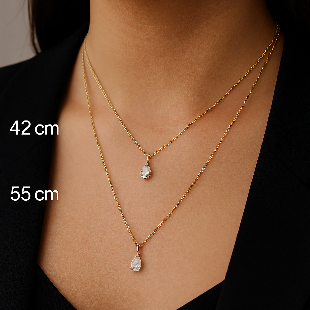 Stiilse naise kaelas on kaks sama disainiga kuldketti, millel on piisad-kujulised teemantripatsid. Üks kett on lühem – 42 cm, teine pikem – 55 cm.