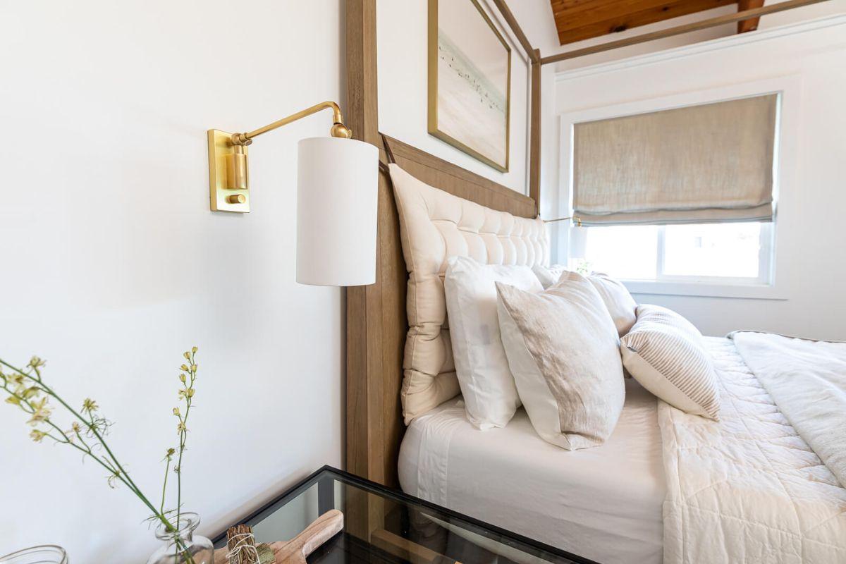 Bedroom wall light fixture ideas with swing arm wall mounted light beside a neutral bed