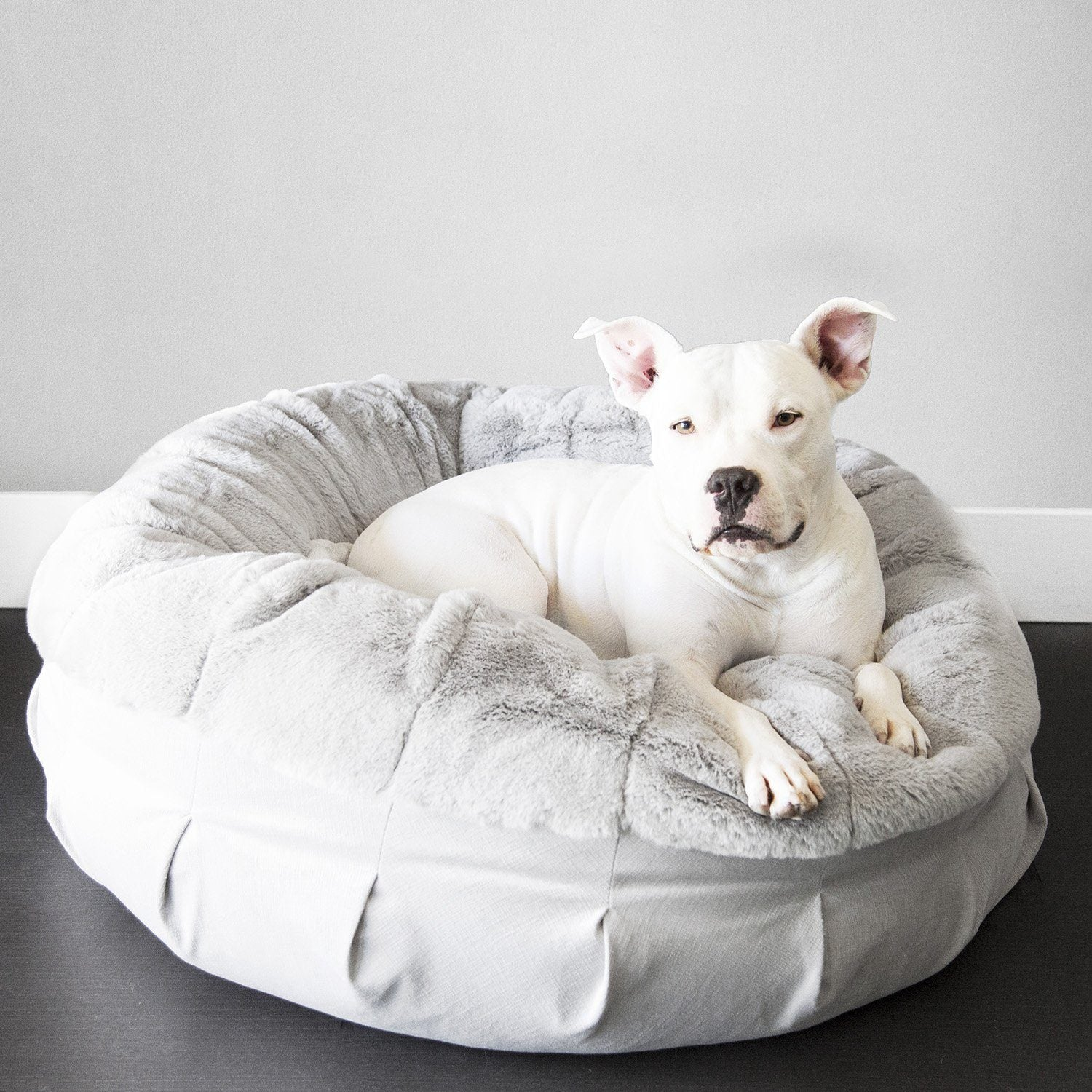 A white donut dog bed with a removable cover and a high bolster design