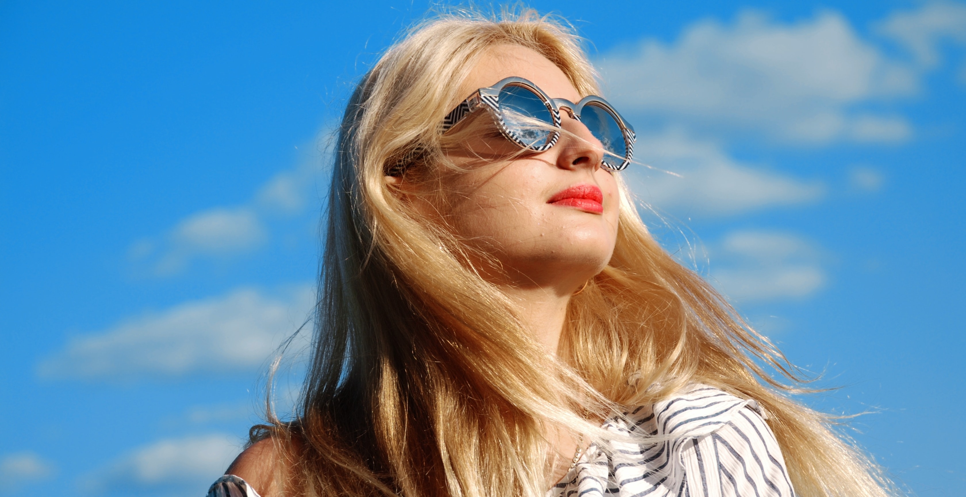 Does OnlyFans take out taxes? Blonde woman with sunglasses looking at the sky.