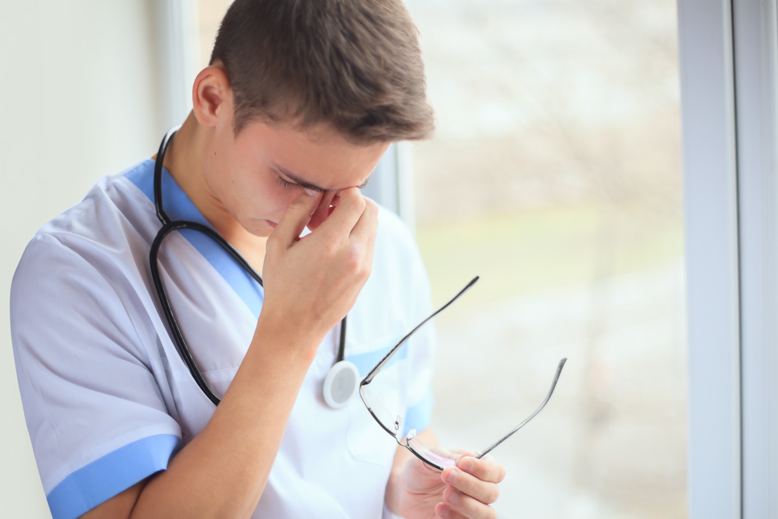 A doctor with his head in his hands