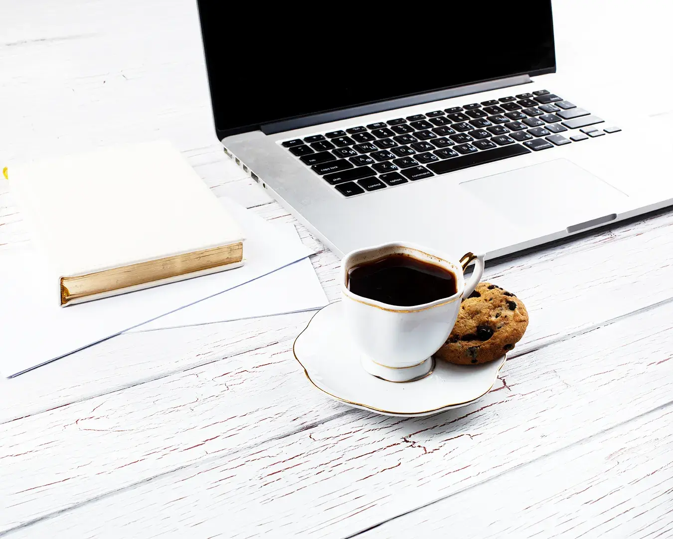 Laptop, coffee cup, notebook, and documents on a minimalist desk, representing restaurant local SEO audit, search engine optimization strategy, Google Business Profile management, and online presence improvement.