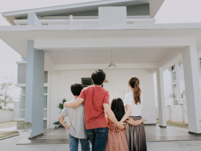 An image showing a happy family contemplating a metal roof. 