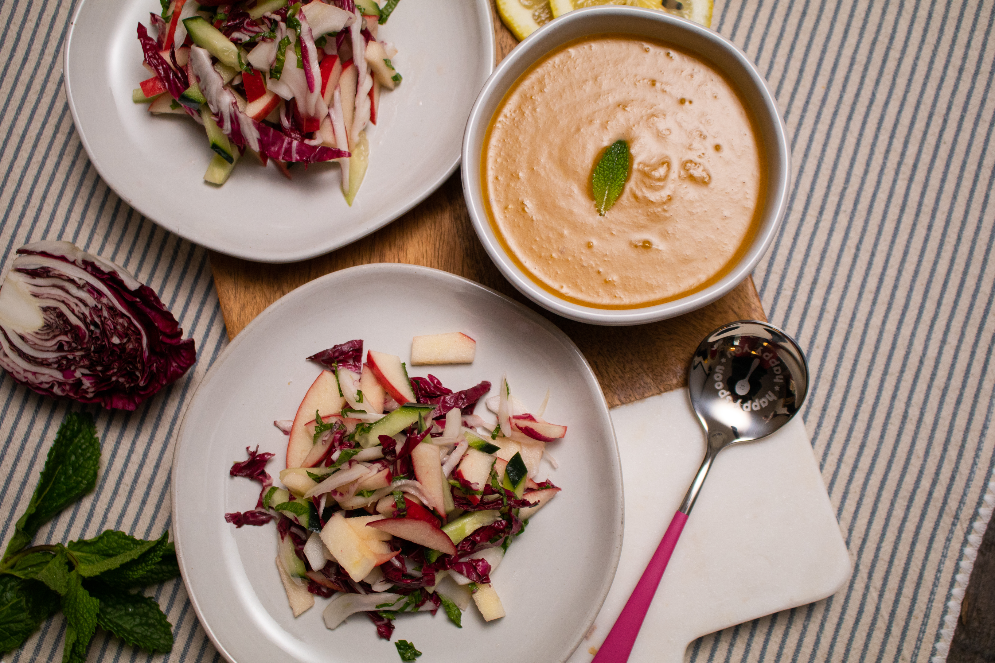 An energizing salad with apples, cabbage, cucumbers, and a bowl of Proper Good Spiced Pumpkin Soup