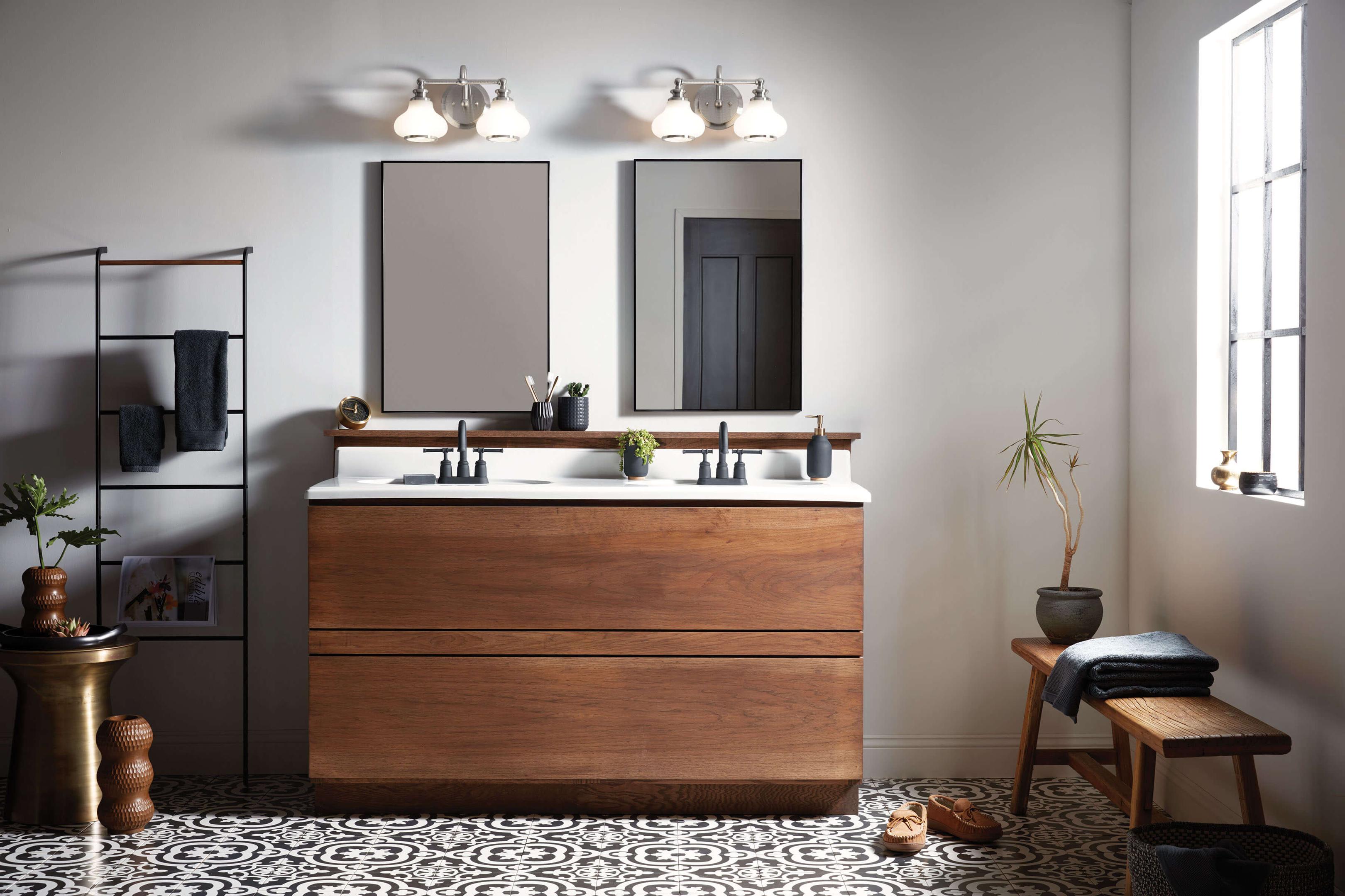 Brushed nickel bathroom vanity lights above the mirror providing balanced illumination in a modern bathroom with straight lines and energy efficient LED bulbs