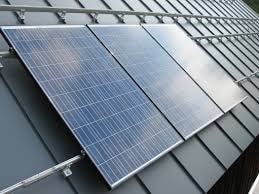 A close up picture of solar panels on a metal roof.