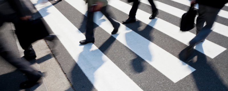 pedestrians crossing a zebra crossing in a major city