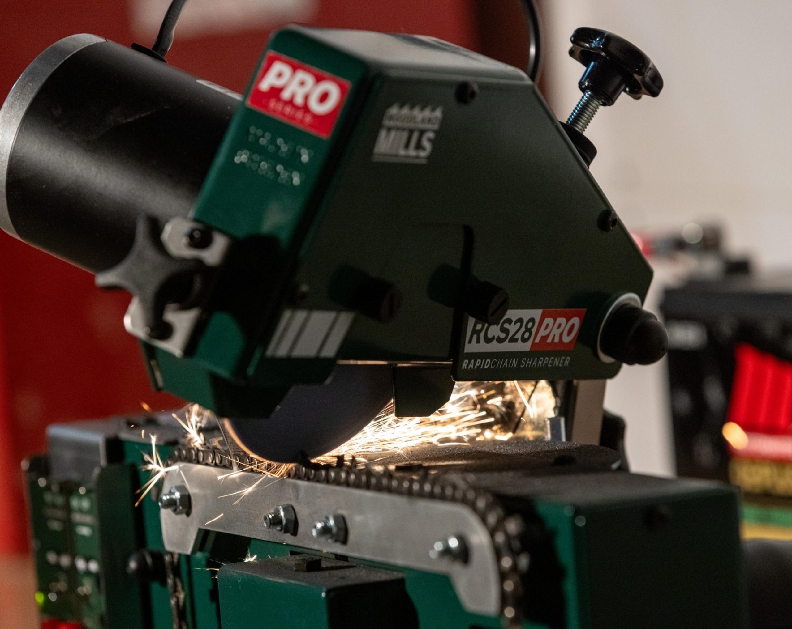 A Woodland Mills RCS28 PRO Chainsaw Chain Sharpener grinding a chainsaw tooth.