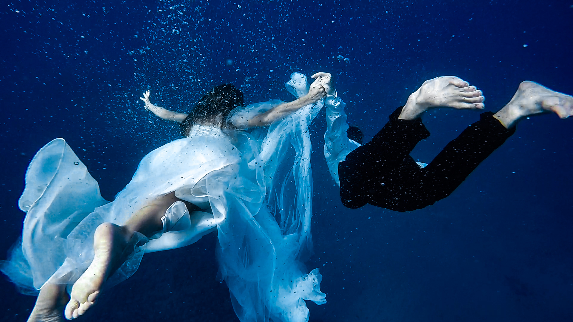 bride diving underwater in a wedding dress