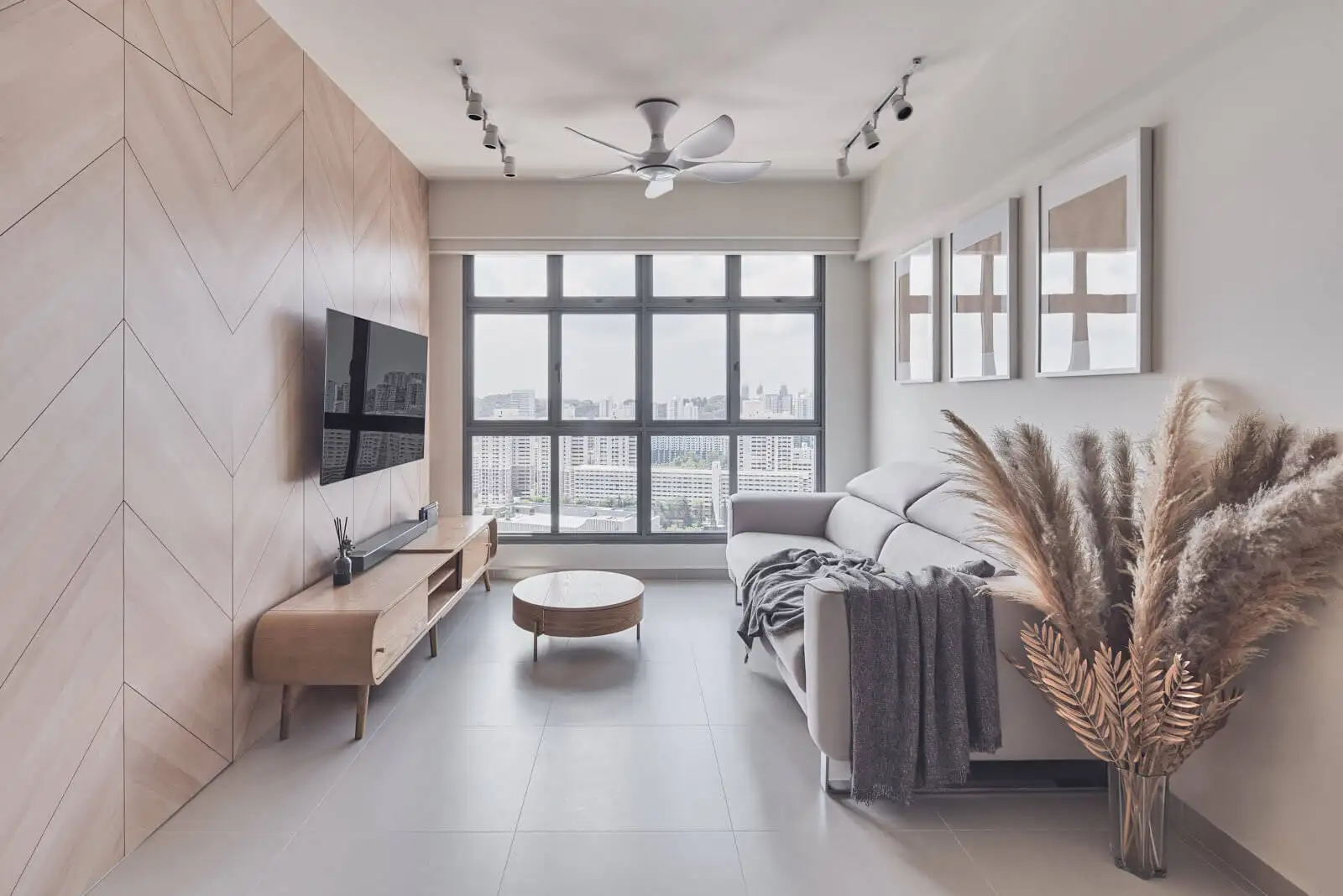 Small sitting room design maximizing natural light with chevron feature wall, wall-mounted TV and raised-leg furniture.