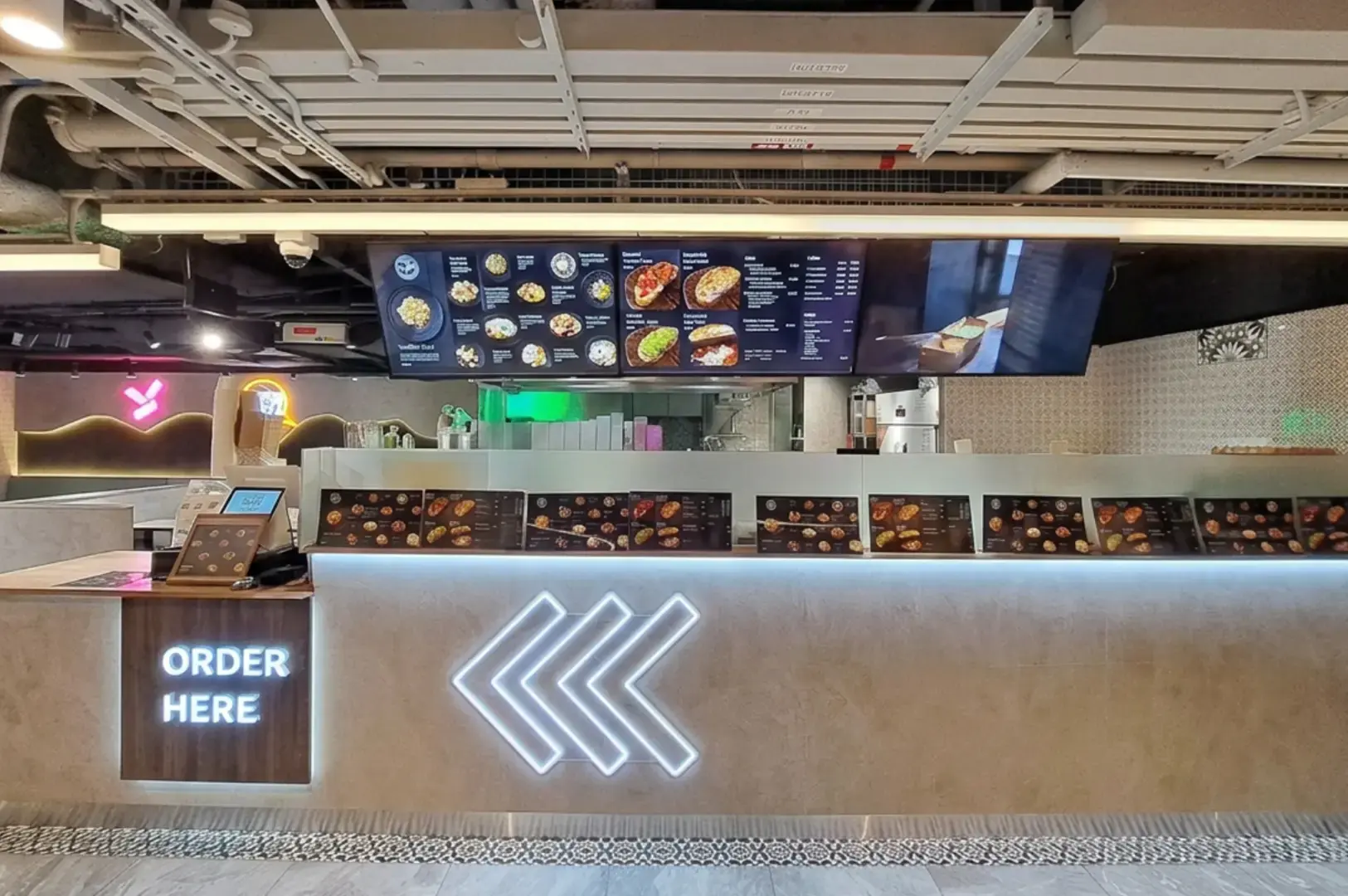 Fresh Pasta by Tangled counter with chevron logo, order-here sign, overhead menu board, and industrial ceiling.