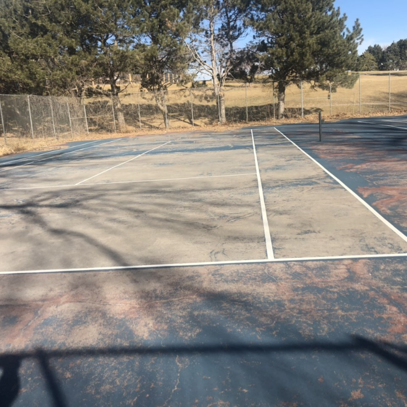 Tennis court showing uneven surface and worn-out texture.