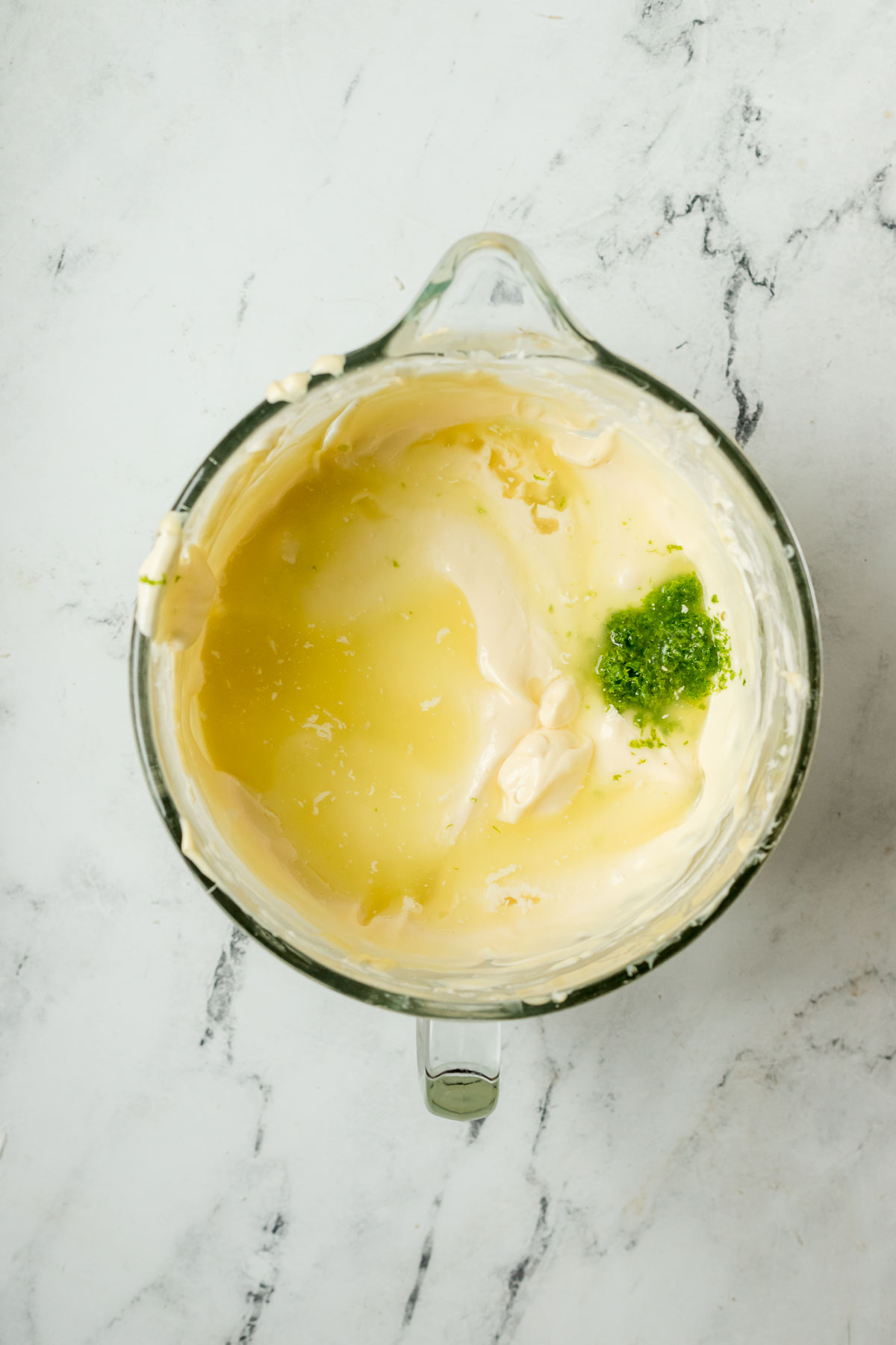 key lime zest and lime juice added to cheesecake batter in bowl