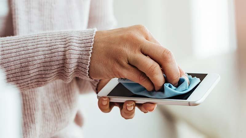 Cleaning a phone screen with a microfiber cloth