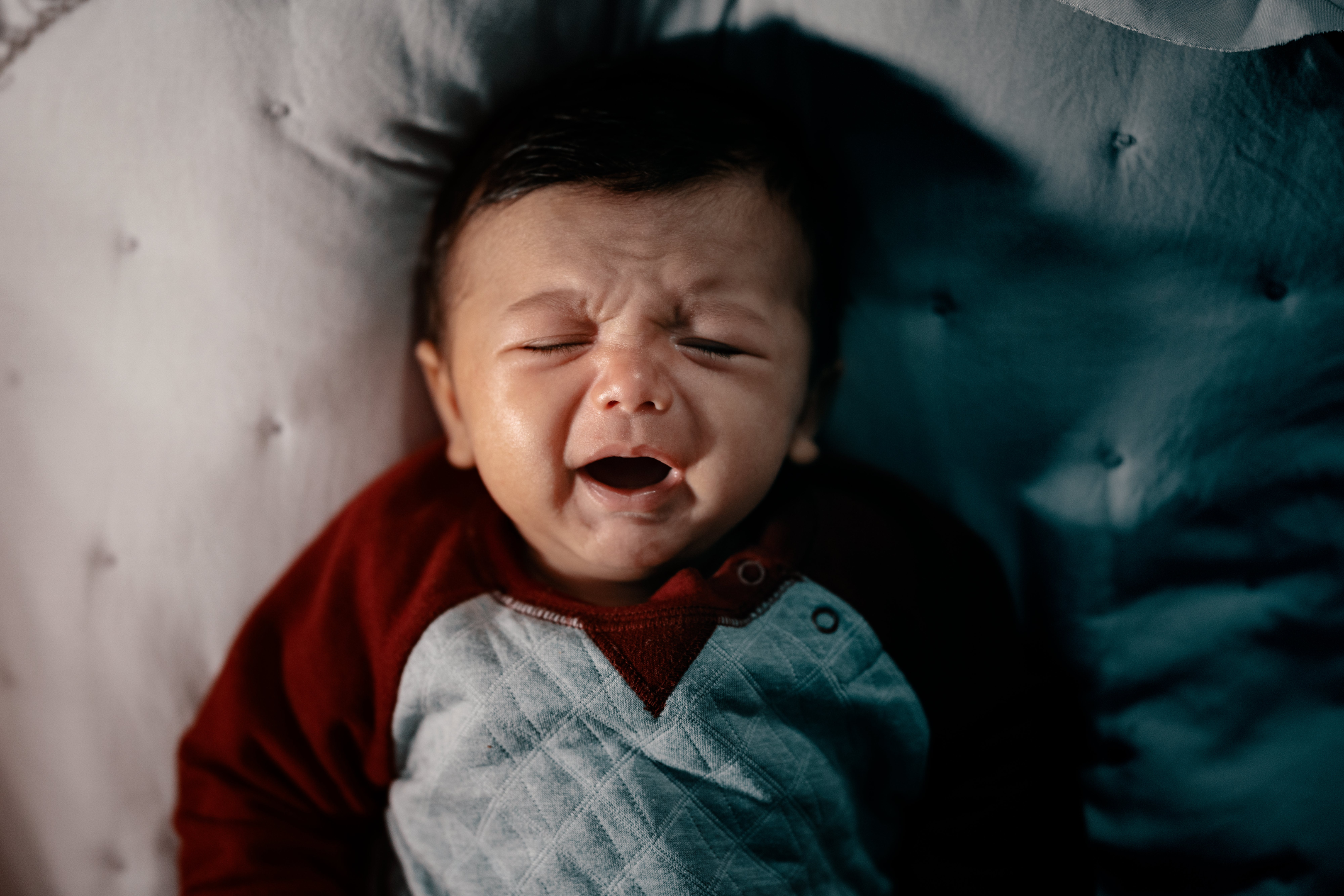 Photo by Gursher  Gill: https://www.pexels.com/photo/a-baby-crying-while-lying-on-the-bed-13156140/