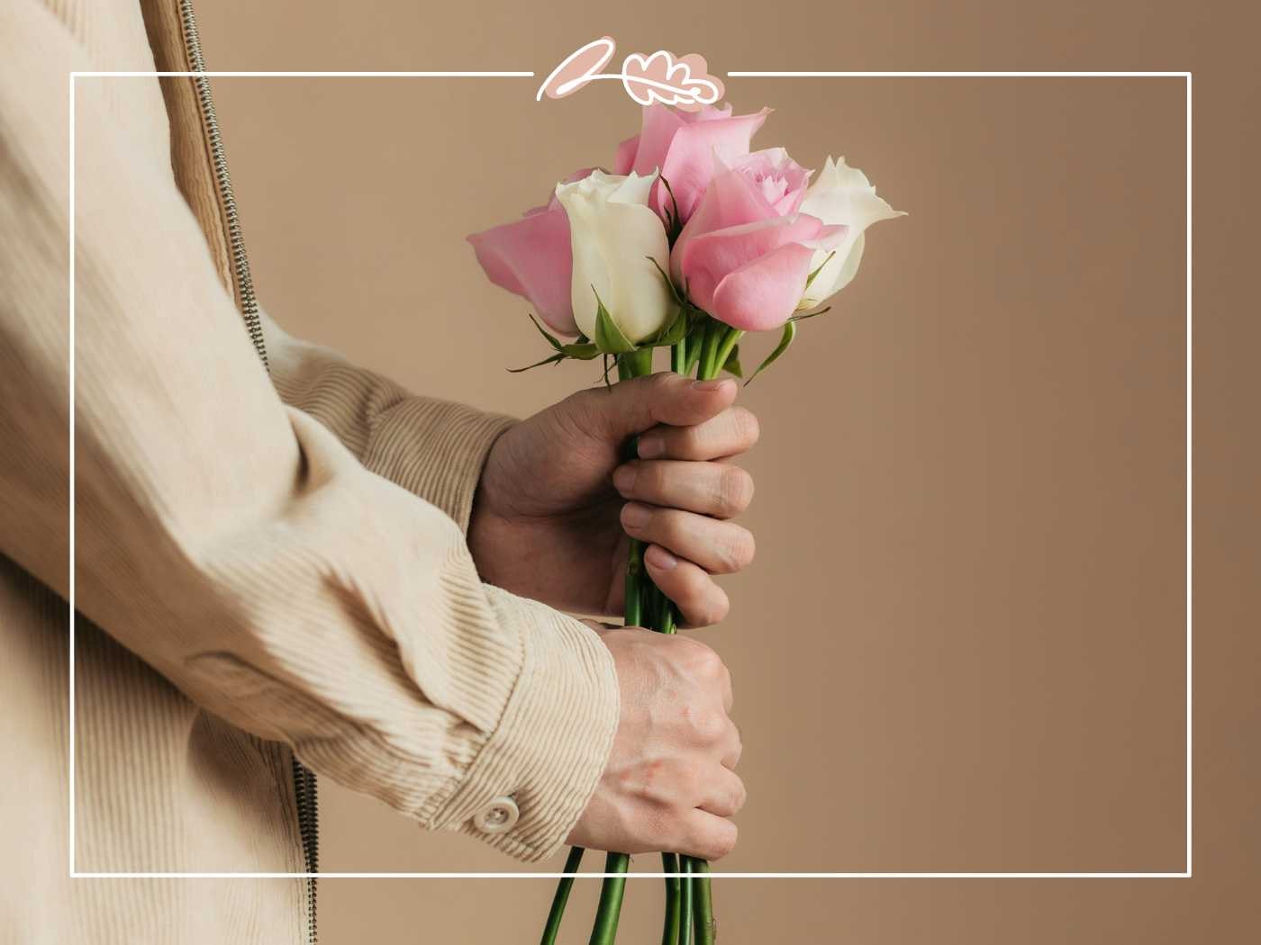 Hands holding a small bouquet of pink and white roses by Fabulous Flowers and Gifts