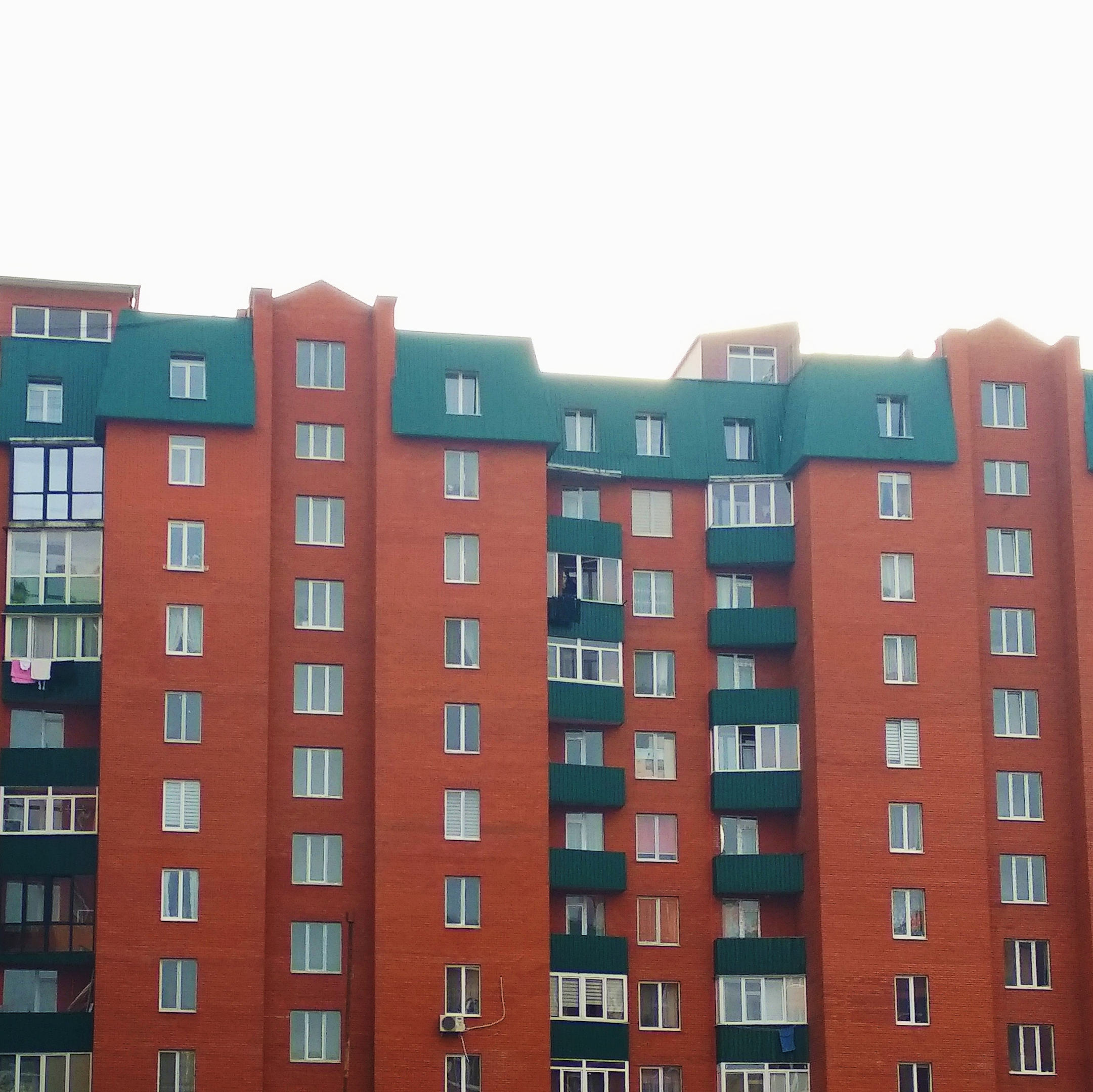 Modern block of apartments with green roofs and balconies 