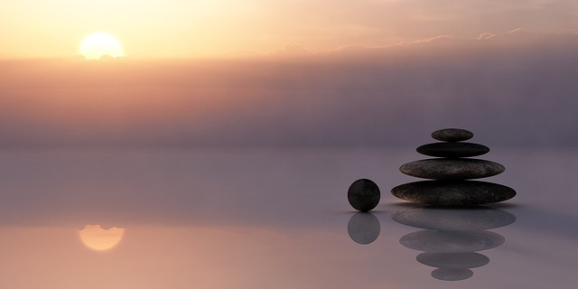 balance, stones, stacked on top of each other on water at sunset
