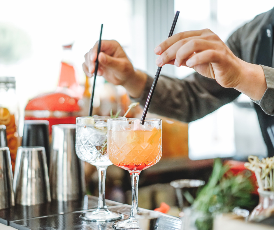 A person mixing a mocktail with a single drop of alcohol