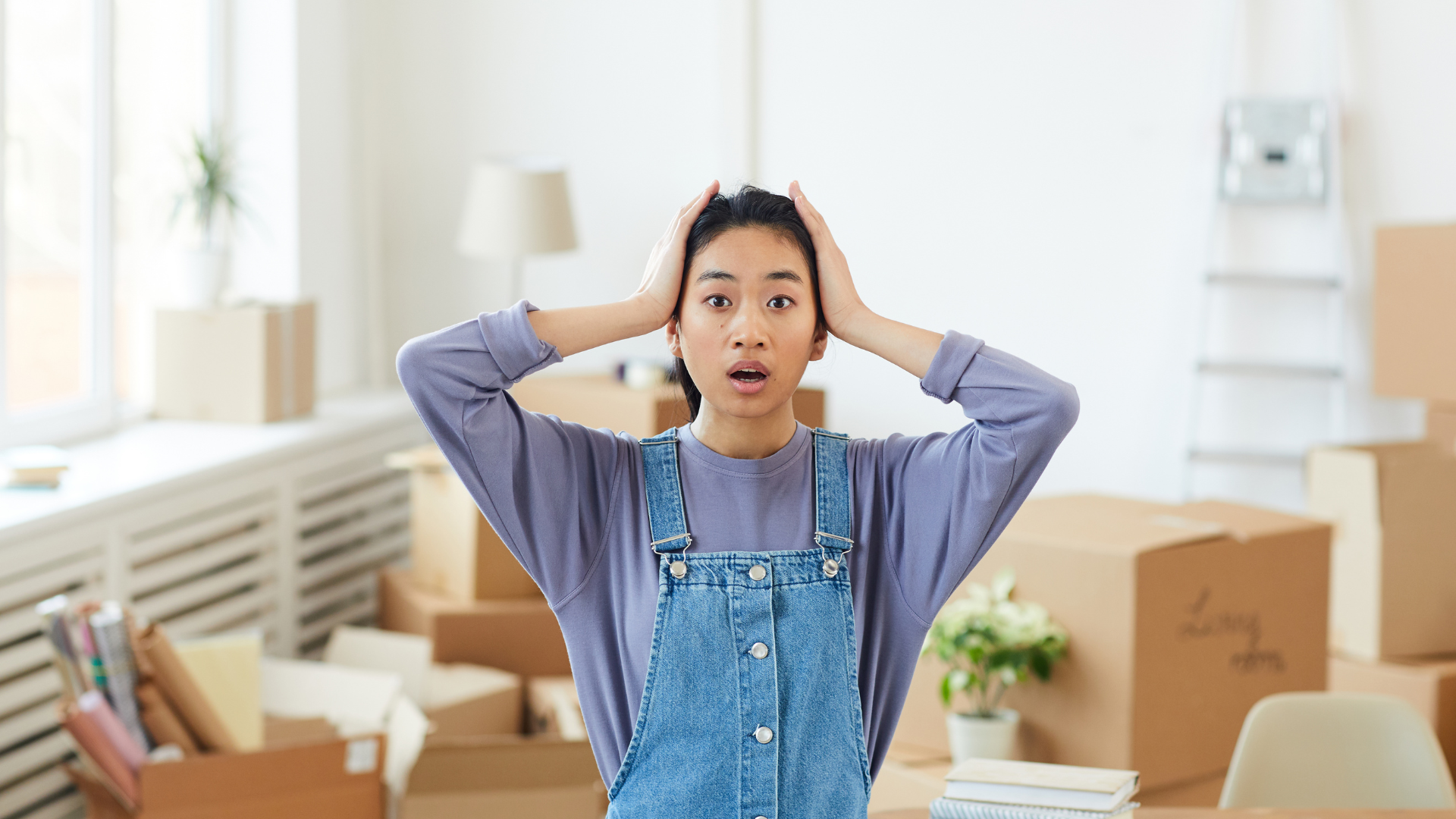 woman surrounded by moving boxes looking flustered
