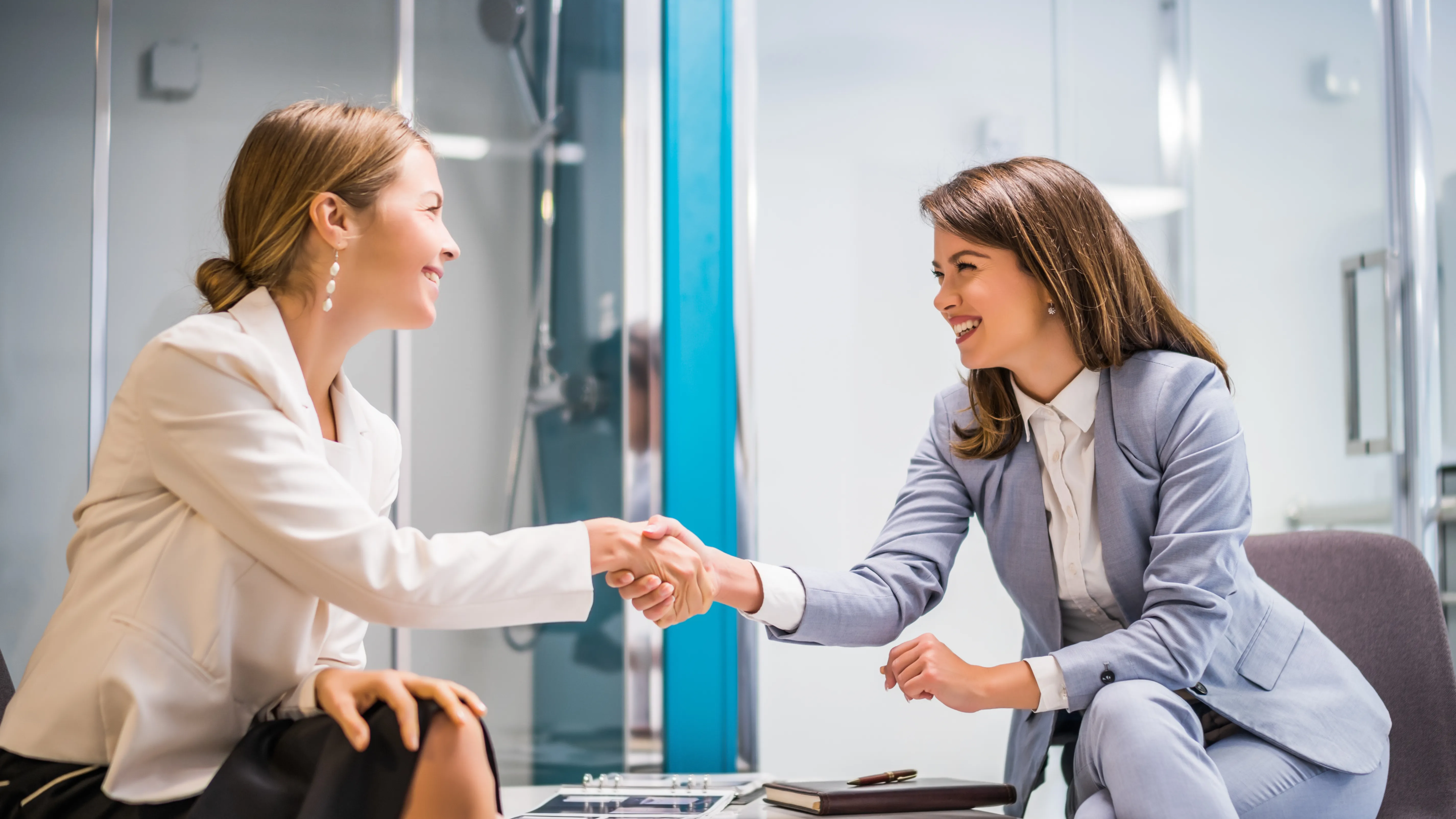 A business owner shaking hands with a client in a high-end bath showroom, representing how a business can model itself to serve niche customer tastes.