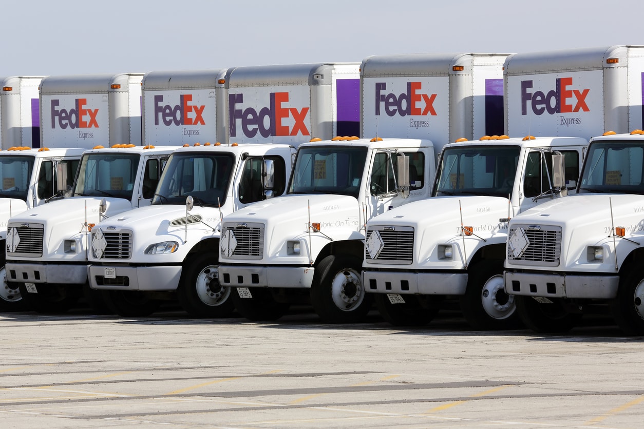 FedEx delivery trucks in a parking lot before departing to complete Sunday deliveries