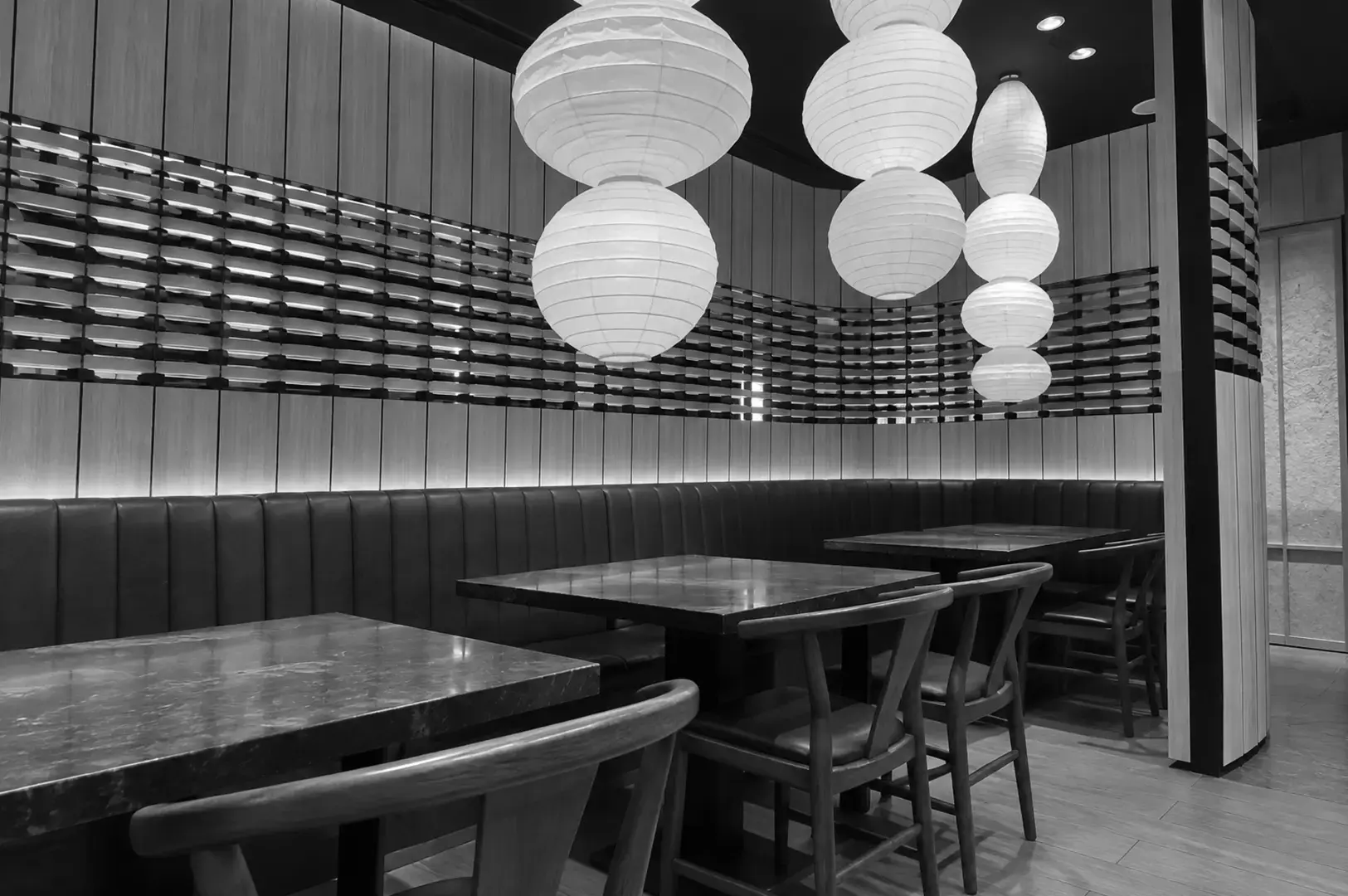 Elegant Japanese restaurant dining area with paper lantern lighting and booth seating.