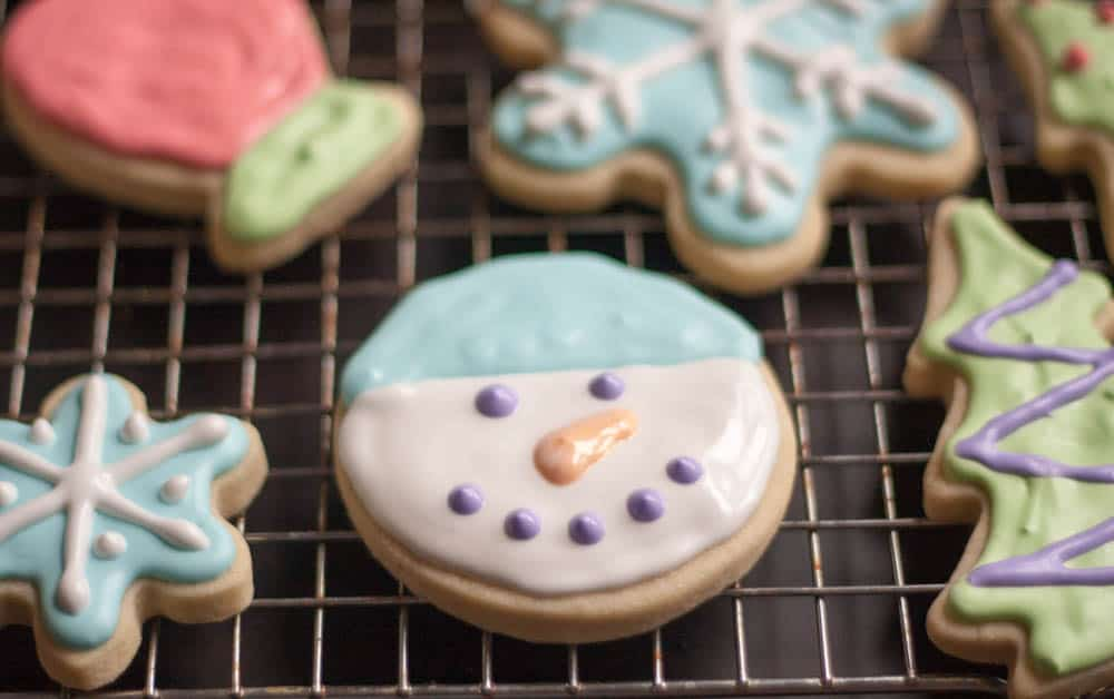 holiday sugar cookies decorated with royal icing on a wire rack