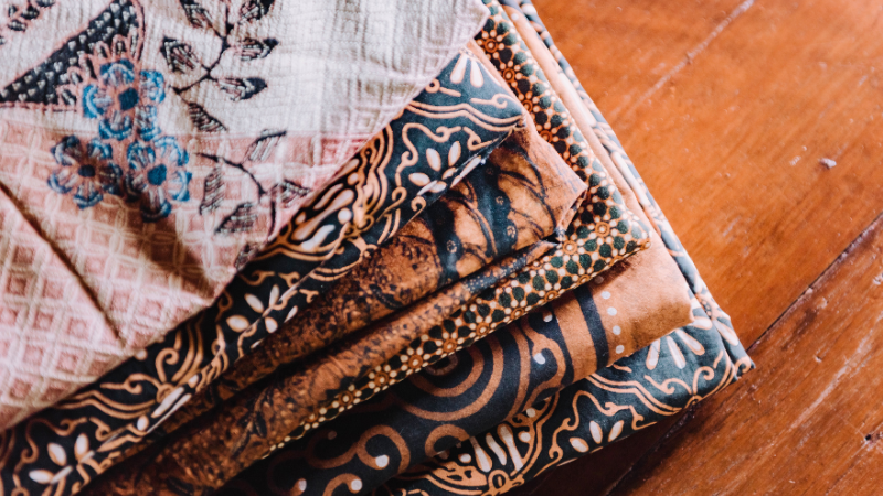 Three different types of batik fabric on a wooden tray