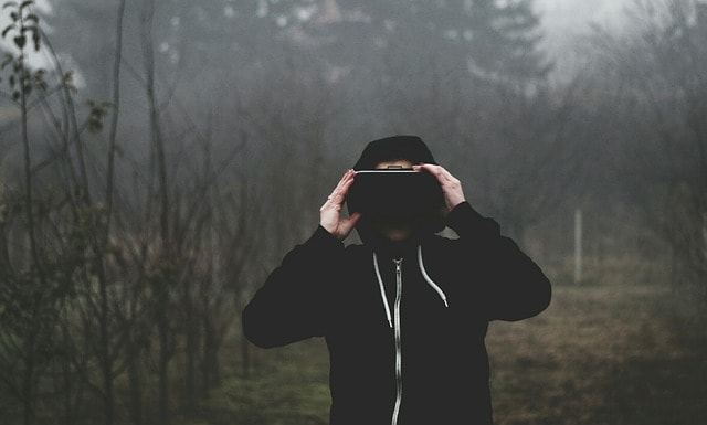 Man wearing VR headset with mist and trees in the background