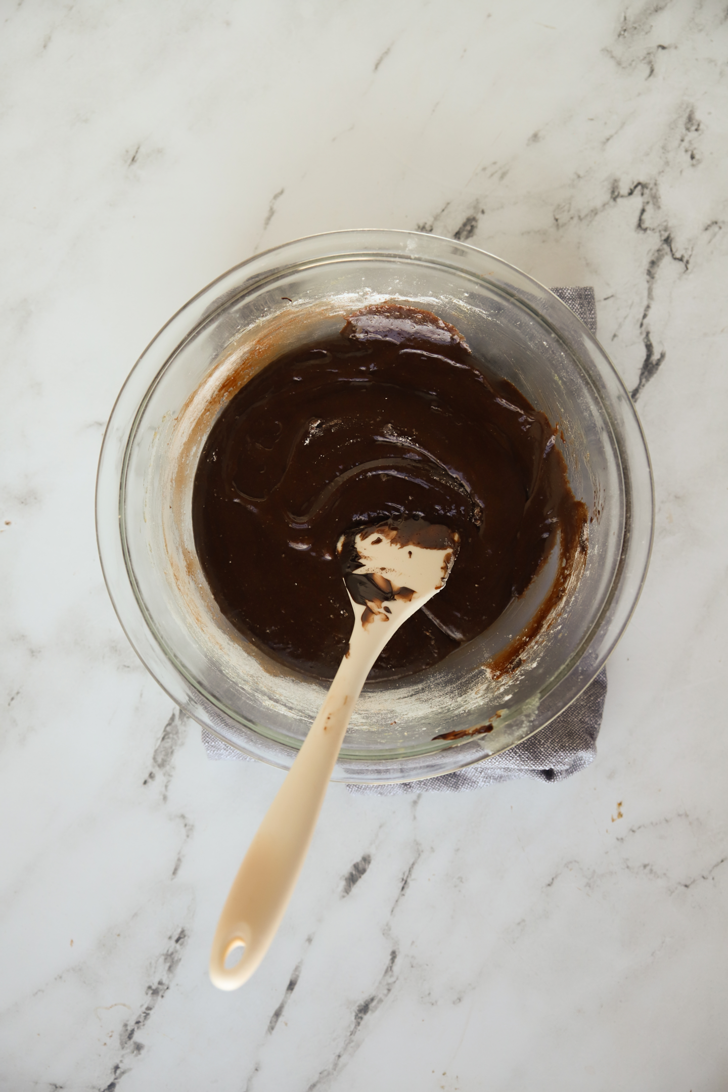 chocolate brownie batter in a large bowl with a rubber spatula