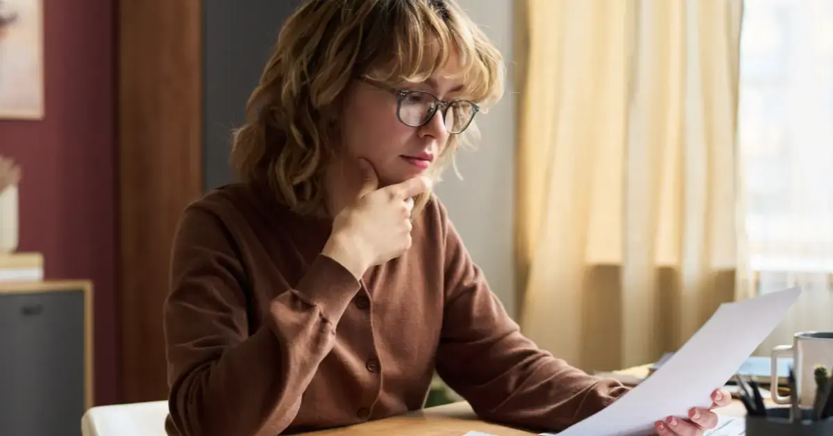 Woman reviewing a joint tax return and IRS notice while seeking innocent spouse relief.