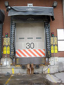 A loading dock with a dock bumper arrangement and a loading ramp