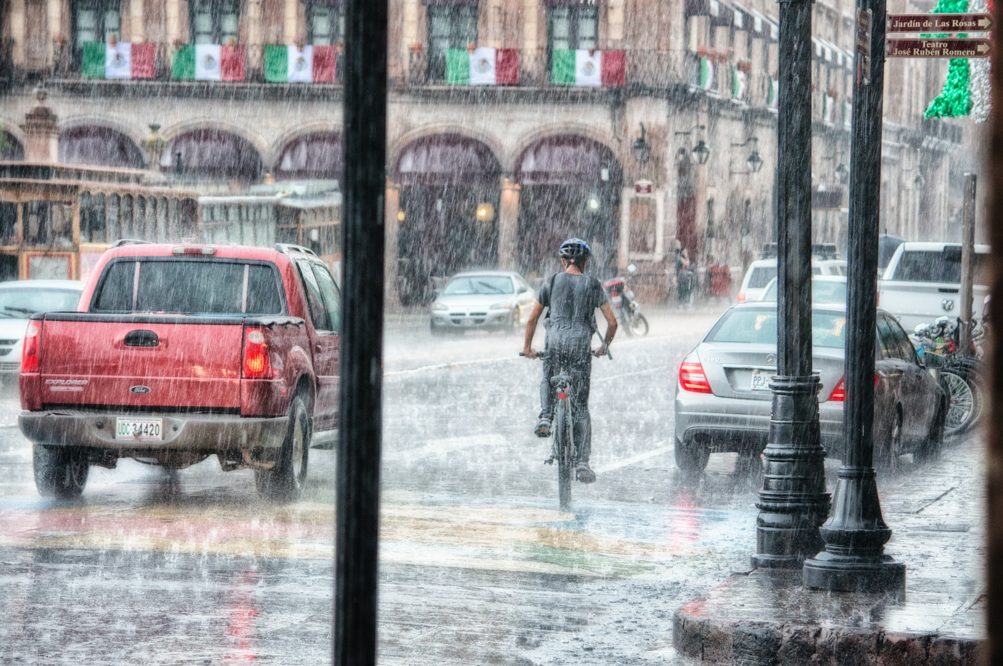 Ciclista pedalando na chuva. Foto de Genaro Servín, Pexels.