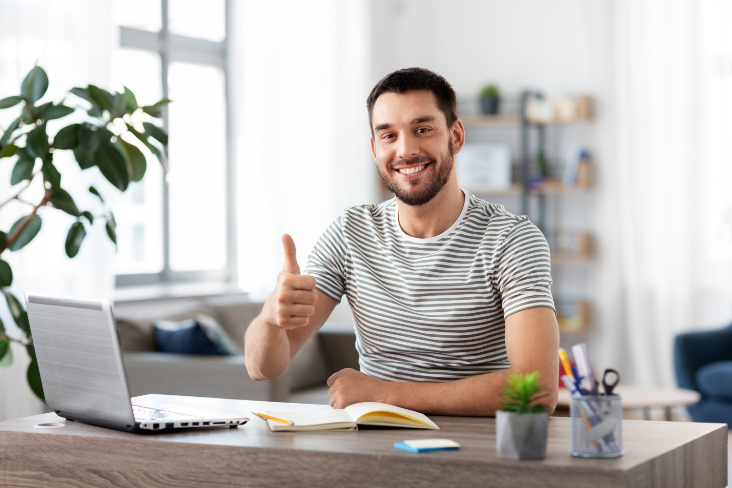 A remote worker smiling and appearing happy while working.
