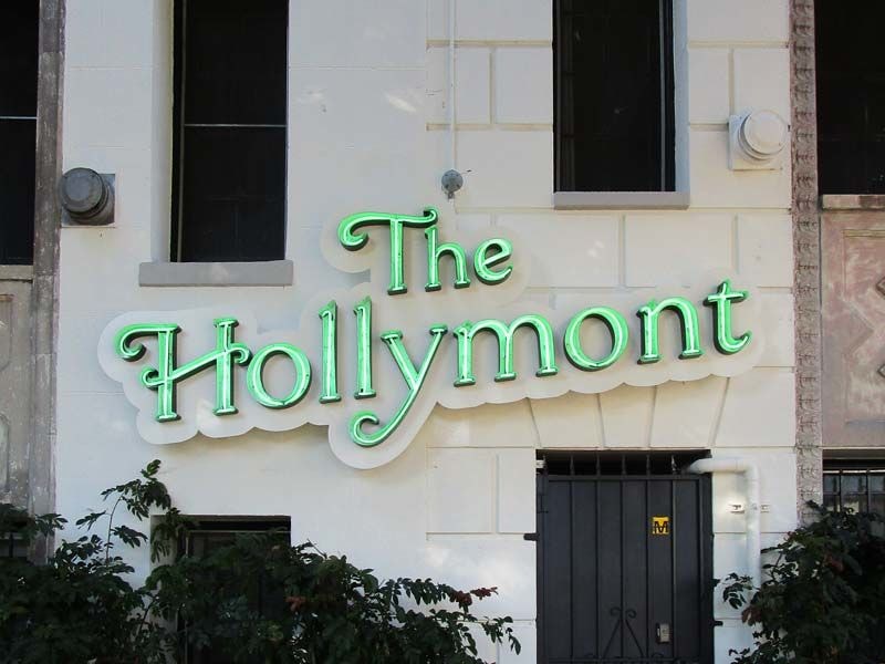 Open face channel letter sign illuminated with neon for The Hollymont apartments in Los Angeles.
