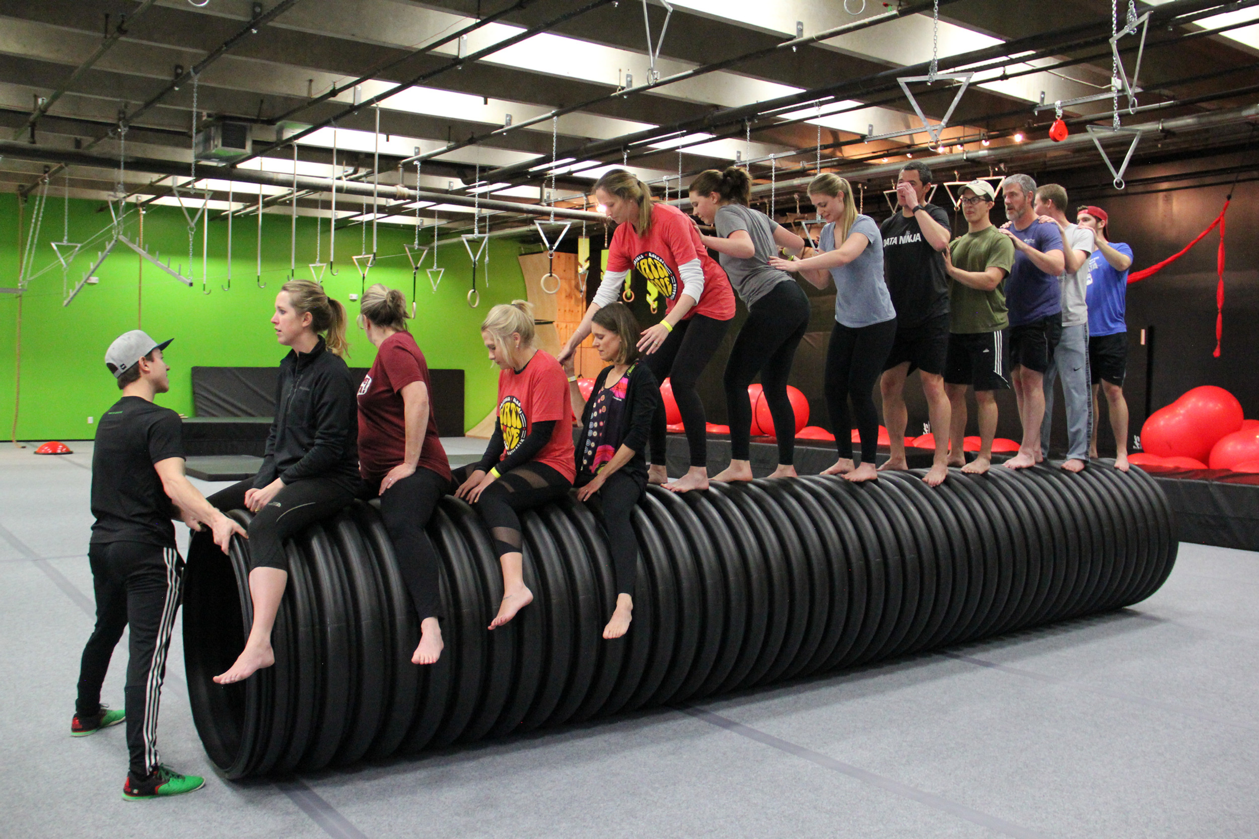 A corporate group completing an obstacle at Warrior Challenge Arena 