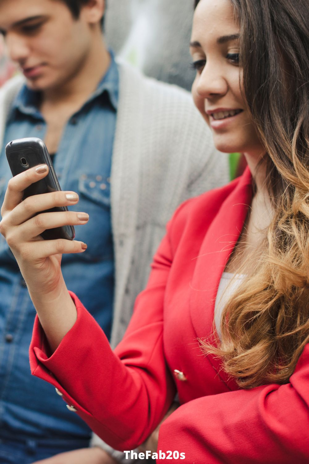 Man and woman checking phones