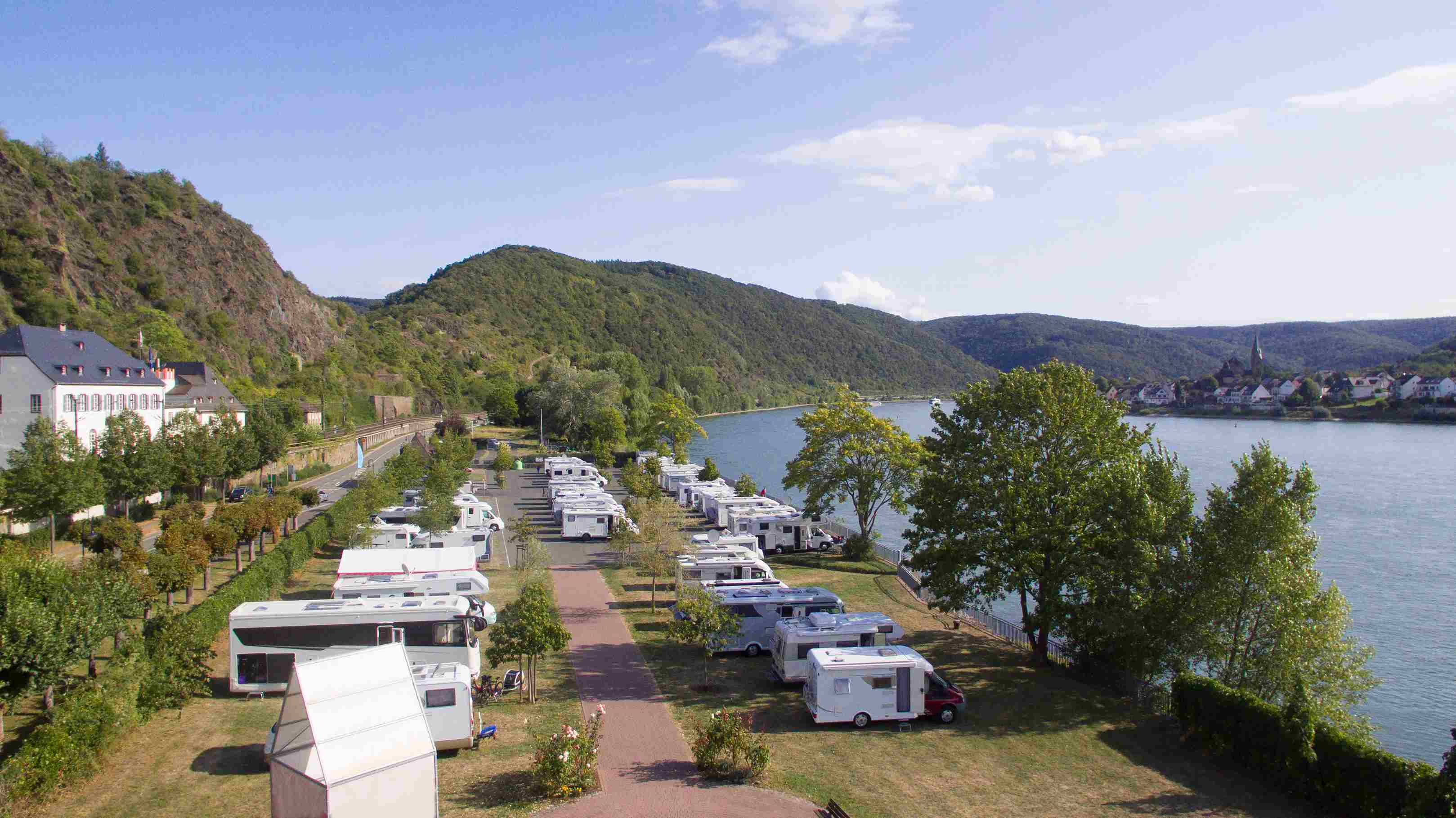Vista aérea de um parque de campismo com várias autocaravanas junto ao lago