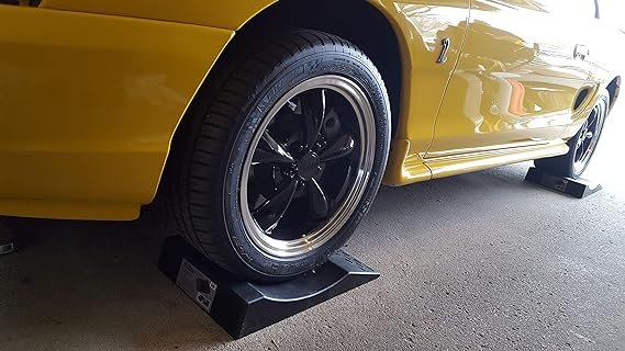 A car with wheel chocks preventing flat spots on tires