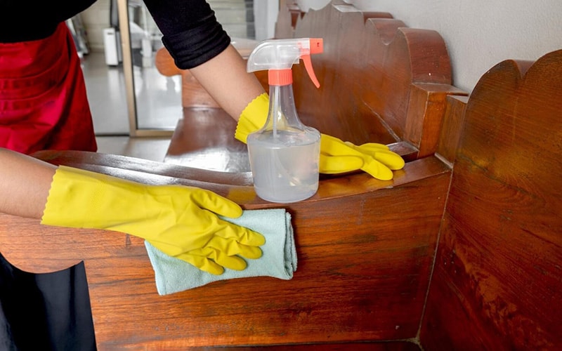 A man using water cleaning on furniture