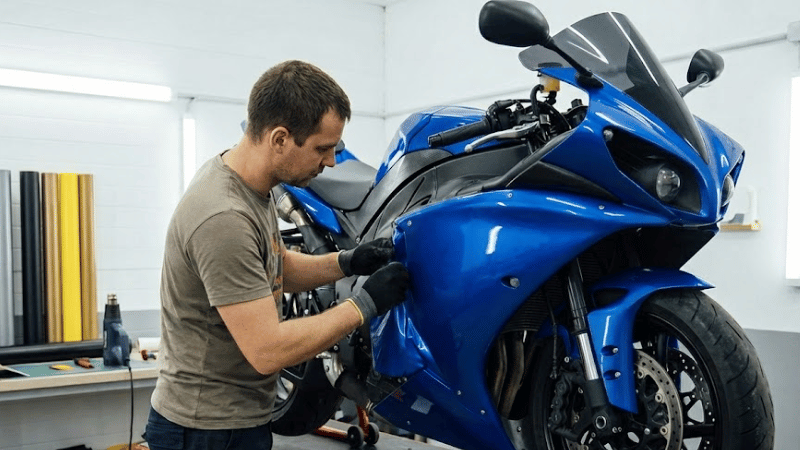 A man is wrapping a motorcycle.