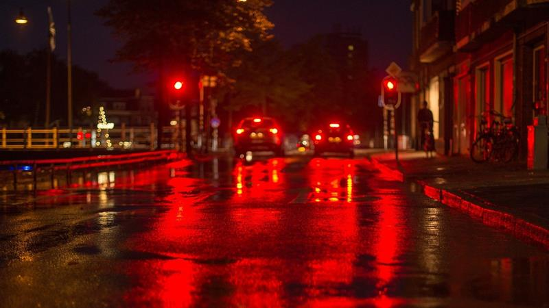 Rear vehicle lights reflecting off a wet road.