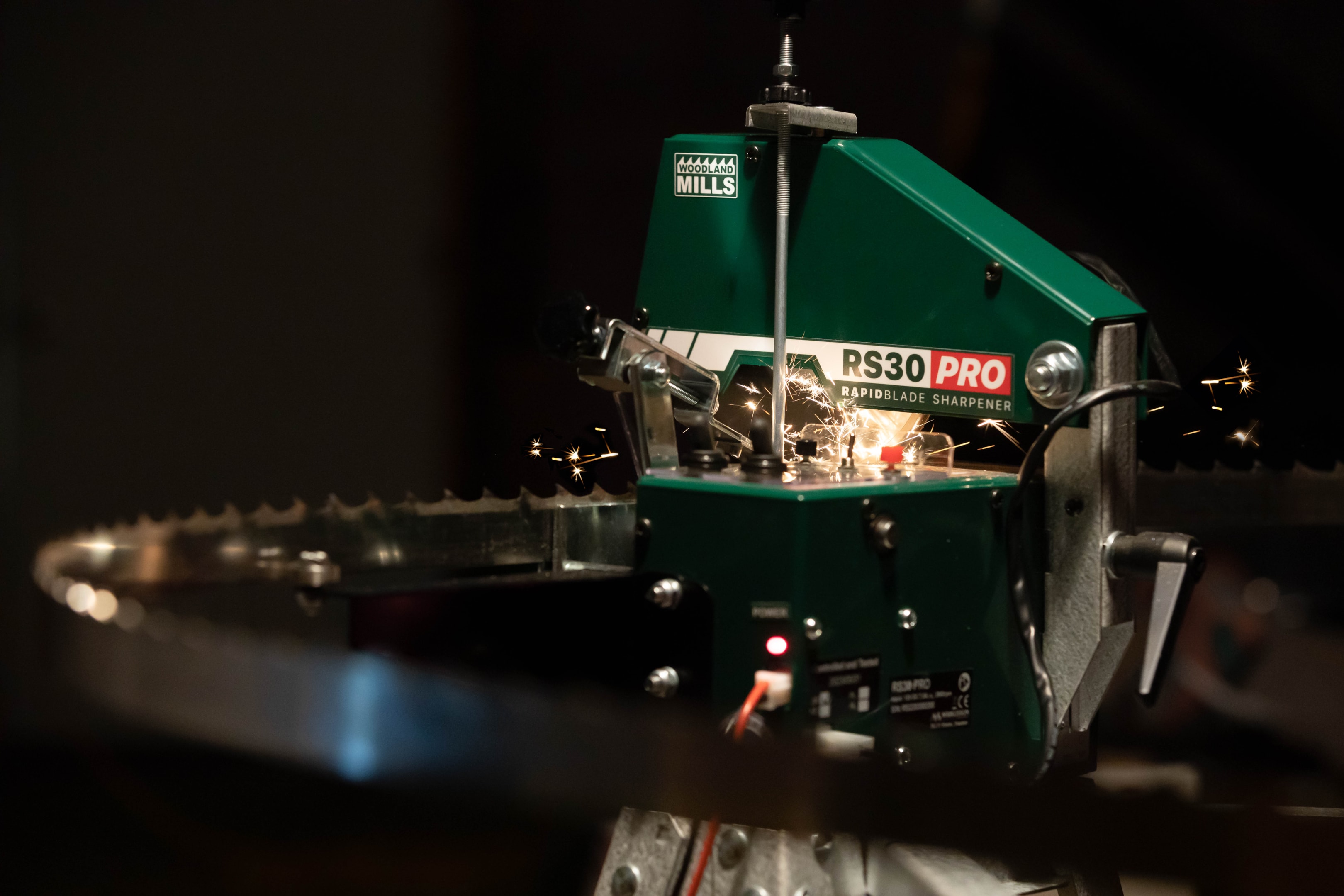 A Woodland Mills RS30 PRO Sharpener sharpening a bandsaw blade. 