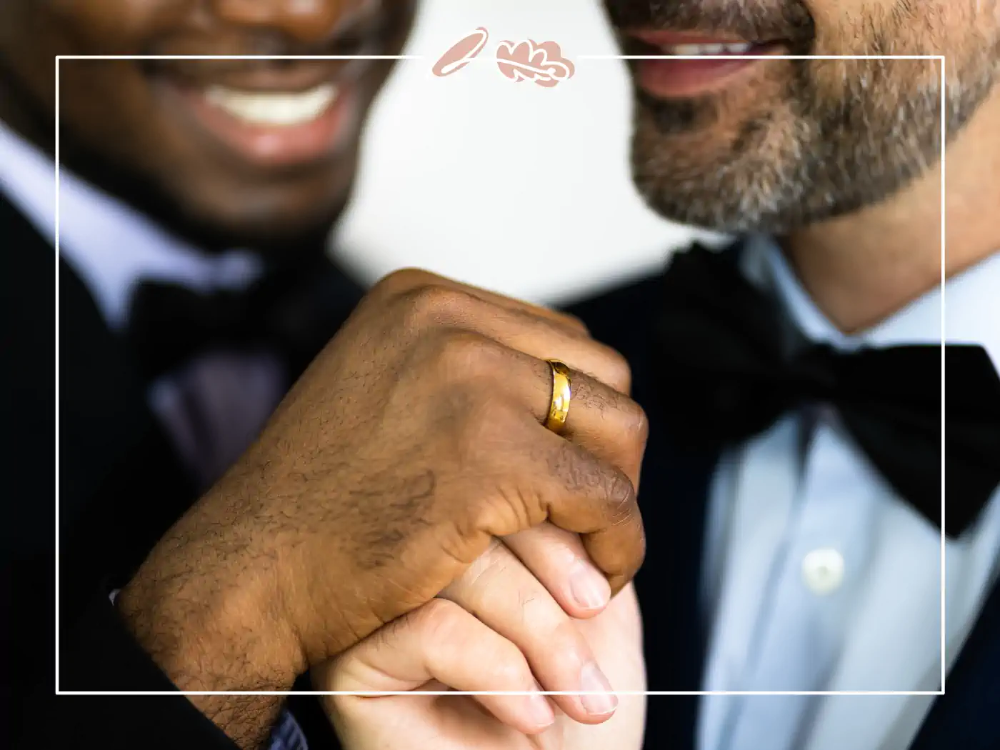 Close-up of two grooms holding hands and smiling, showcasing their wedding rings. Fabulous Flowers & Gifts